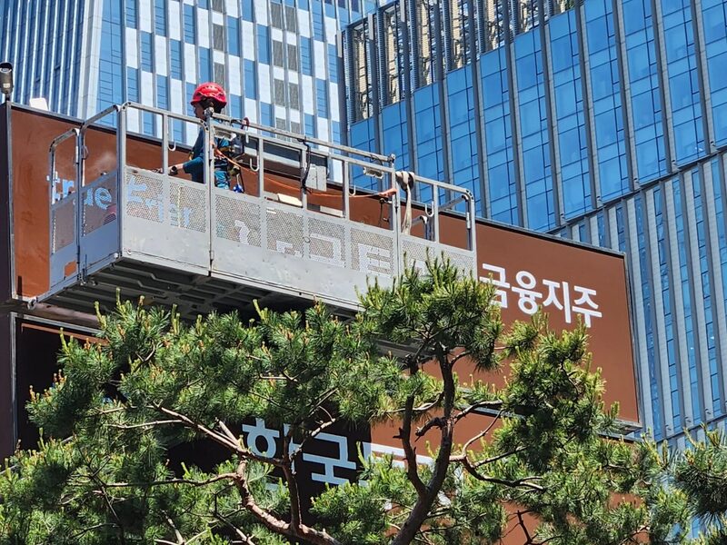 한국투자증권 지점 외부간판 세척 작업 중인 고소작업대